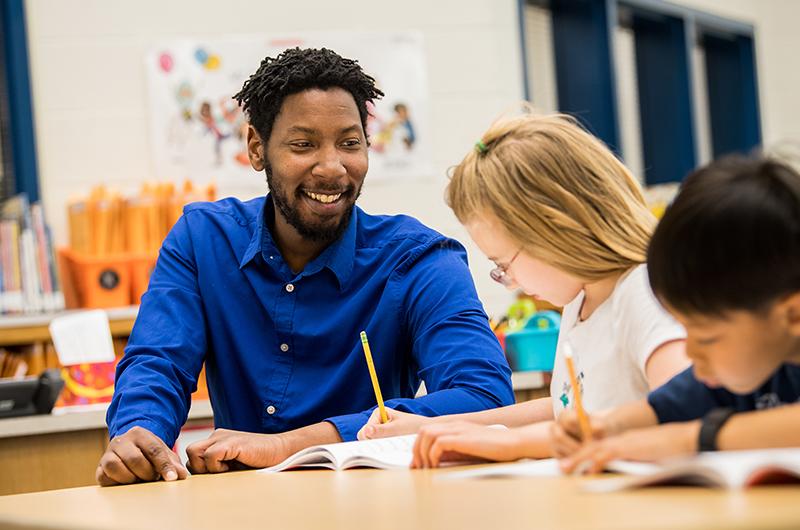 A teacher giving handwriting instruction