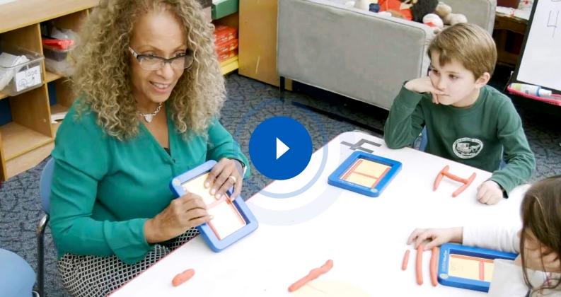 Teacher guiding students with Roll-A-Dough Letters for letter formation