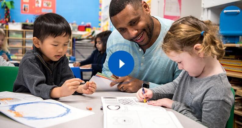 Teacher supporting early handwriting development with crayon