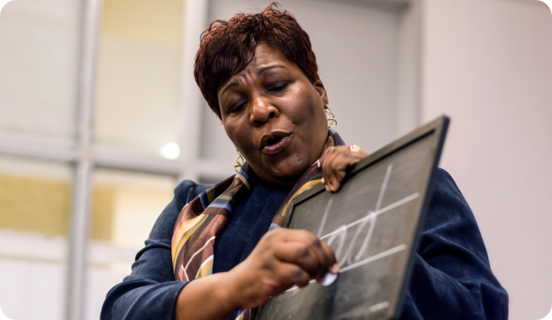 Trainer uses a wet-dry-try board to model handwriting instruction during an educator workshop focused on foundational writing skills.