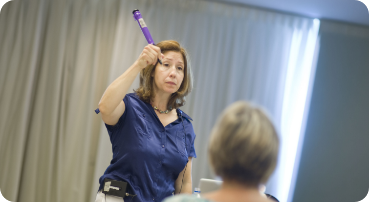 Instructor demonstrates a purple handwriting tool during a professional development workshop focused on writing and fine motor skills.