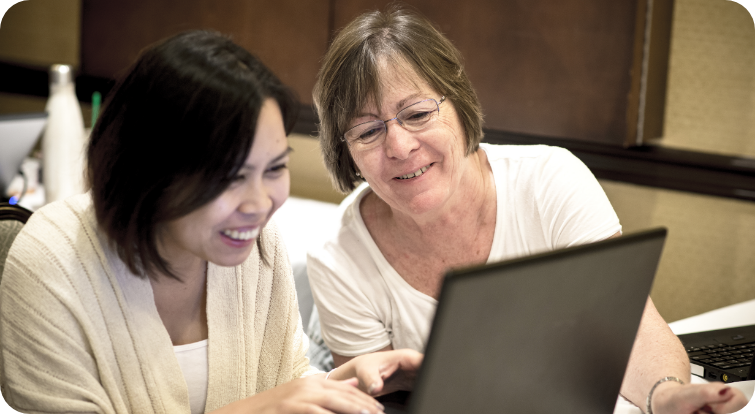 Educators work together on a laptop during a keyboarding and digital literacy training session.